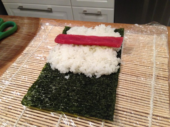 making sushi at home, adding wasabi and tuna